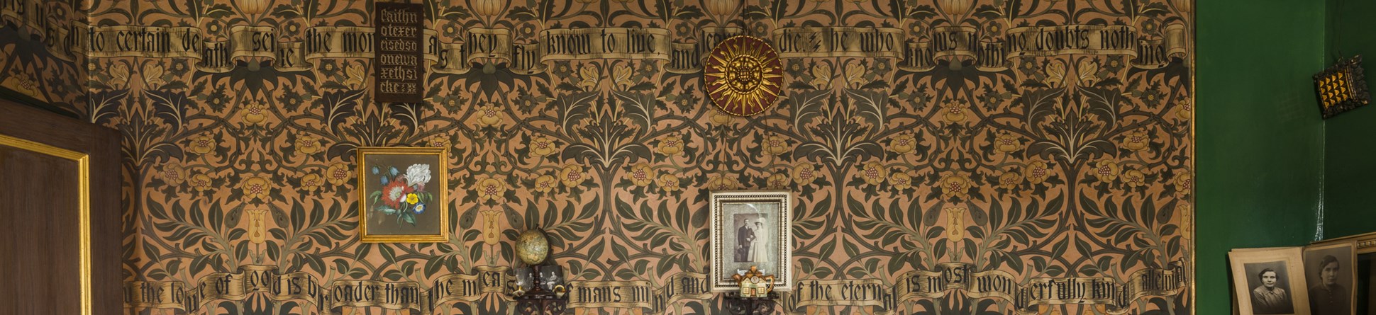 The intricate green and gold design of a wall in the drawing room at artisan decorator David Parr's House in Cambridge