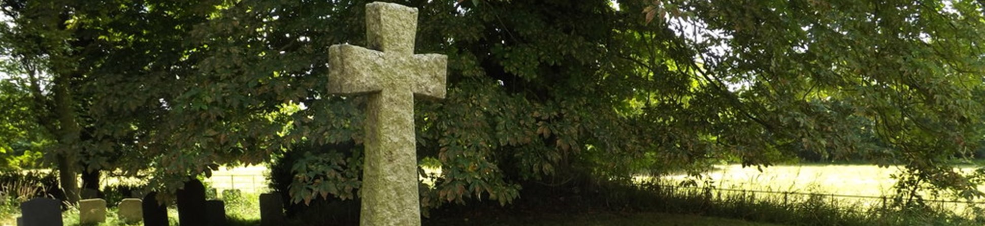 Stone crucifix standing on a rough carved rock with one face engraved with names of members of the local cummunity who lost their lives in the First World War.