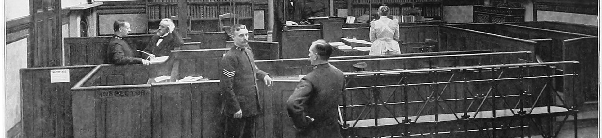 Court room, almost empty but for six people including three policeman going about their work or talking.