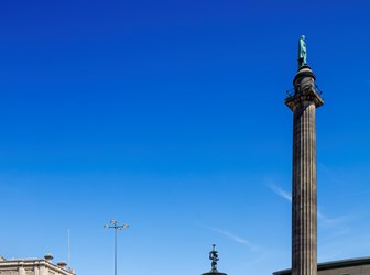 Photograph of the Wellington Column, Liverpool, with a jogger running past its base.