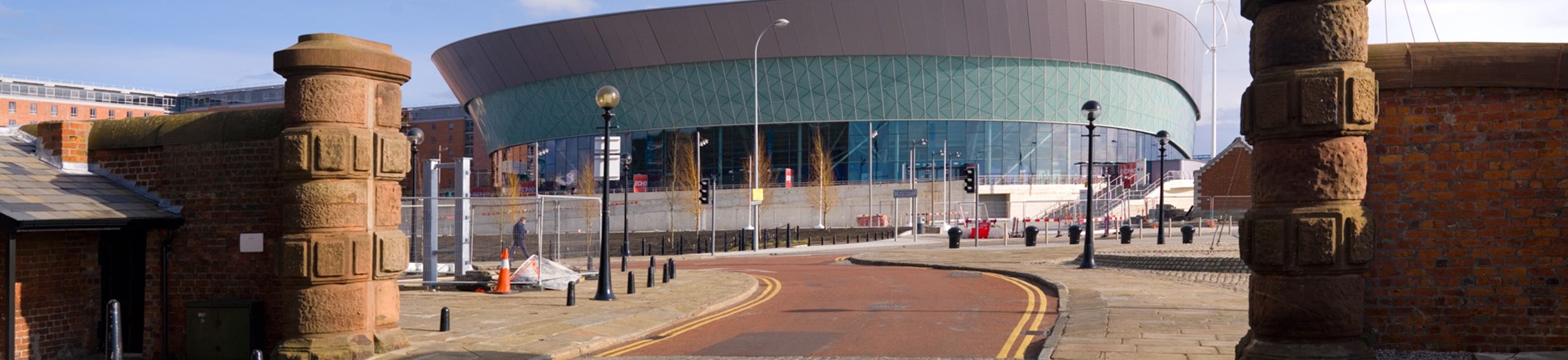 Conference centre viewed through large sandstone gateway.