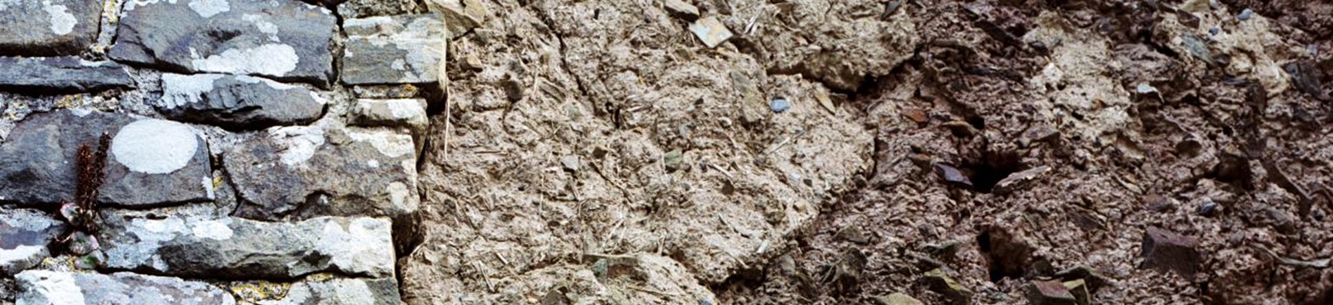 exterior detail of the stone and cob wall of a barn