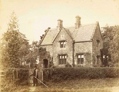 A man standing at the gate of a house