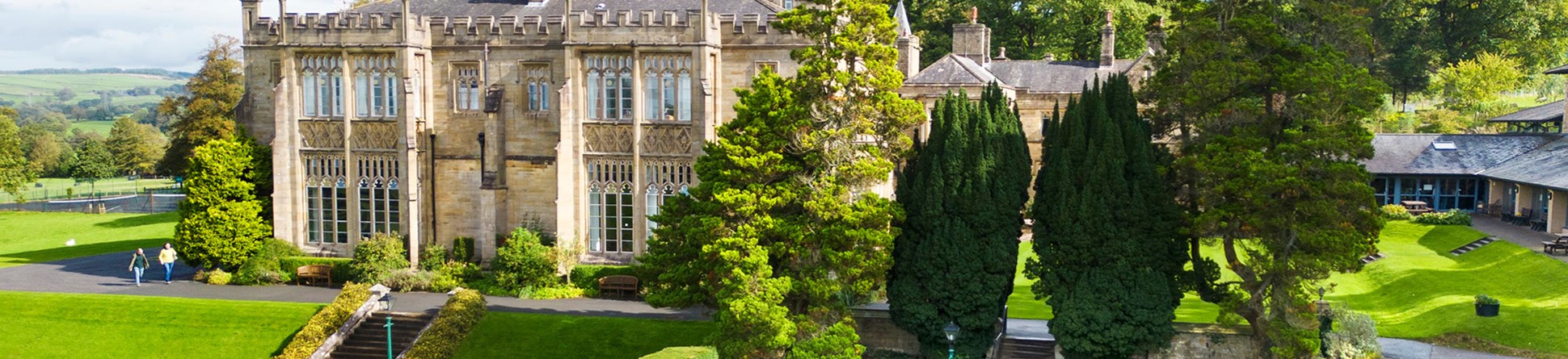 Exterior, drone image of Capernwray Hall and its formal 'Mawson' rose garden. View from west. 