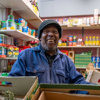 A smiling market stall holder.