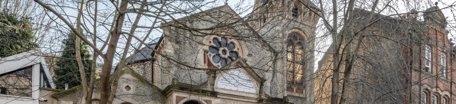 A stone building with a tower and decorative windows.